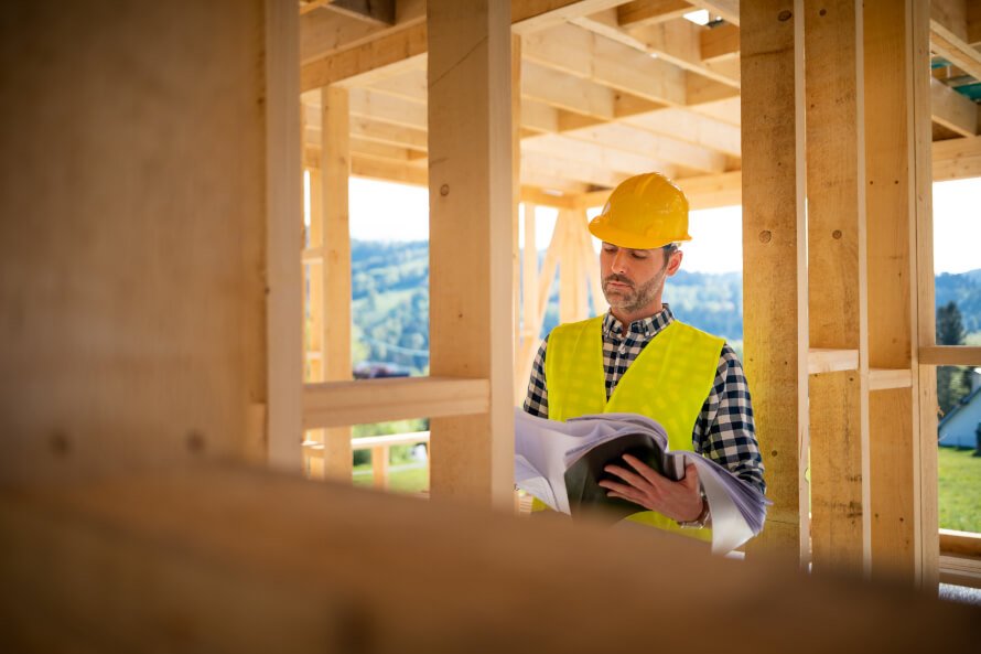 engineer-with-hardhat-and-blueprints-on-building-s-5J9RL5B.jpg